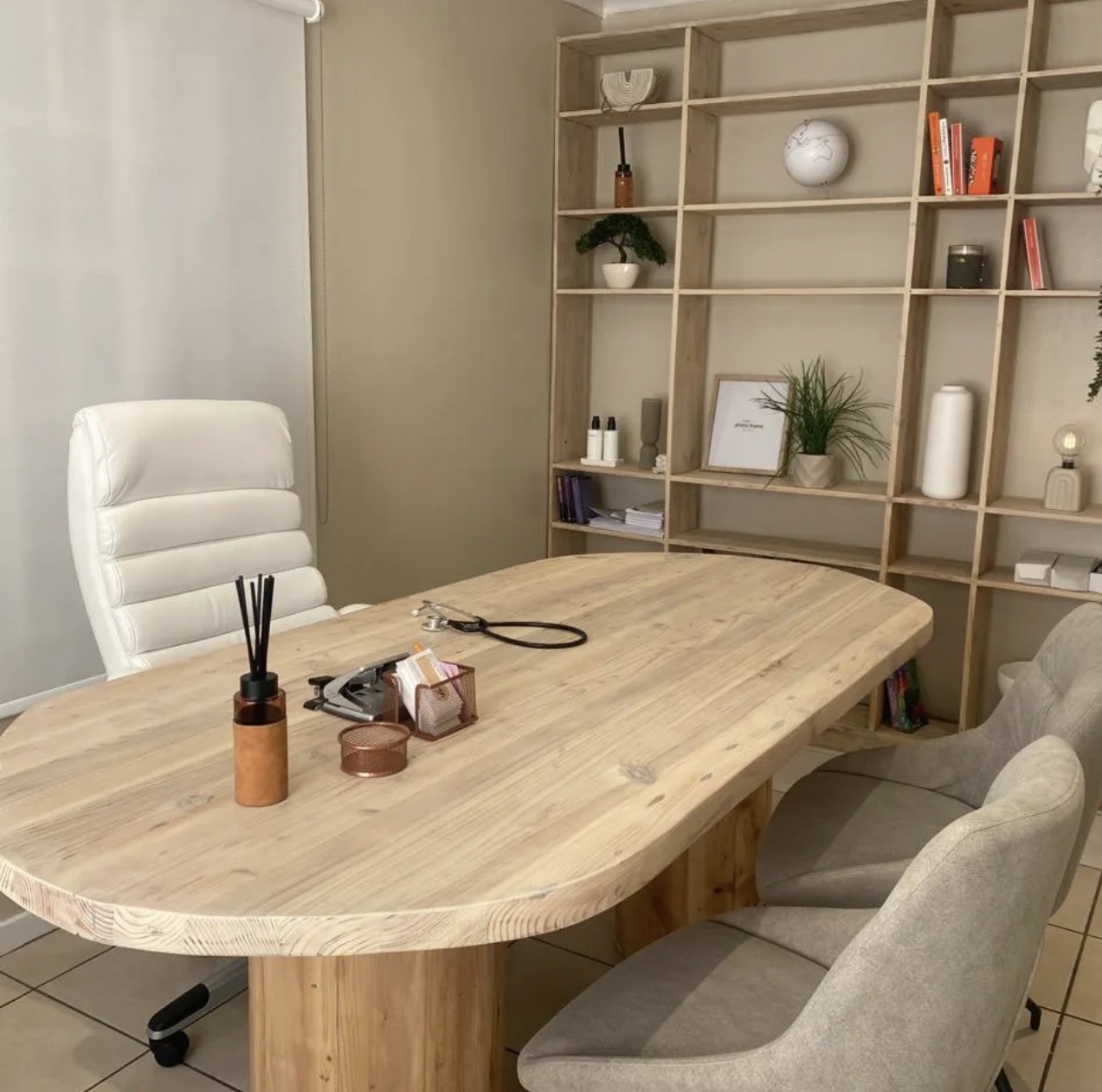 A warm consultation room with a light-wood table, stethoscope and natural styling