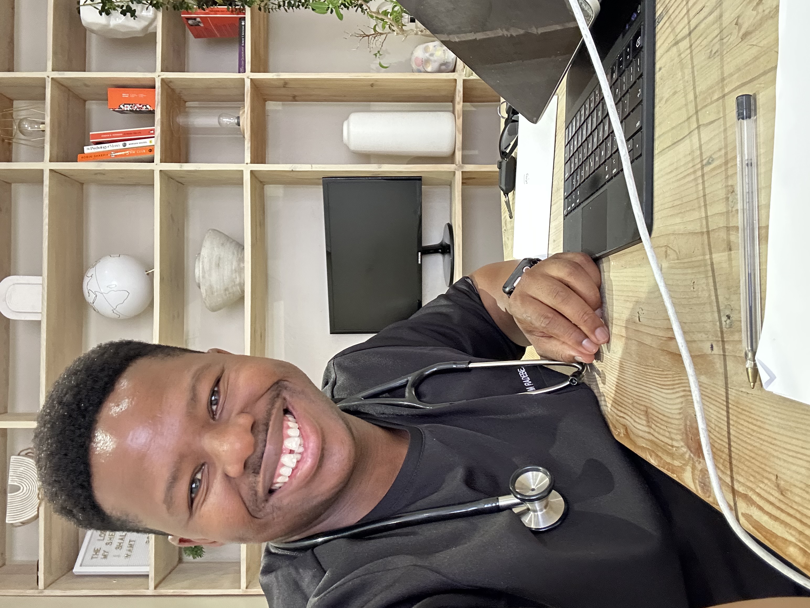 Dr. M. Radebe smiling at his desk at Kira Med Medical Centre